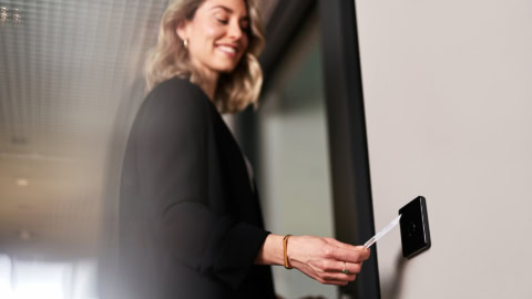 Frau öffnet Tür mit Ausweis am IF-800 Zutrittsterminal