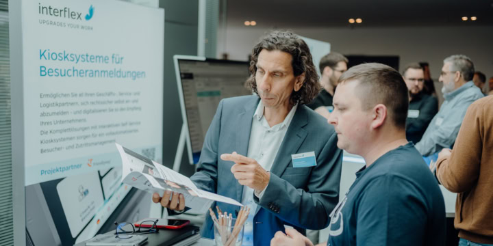 Interflex employees explain kiosk systems for visitor management to interested parties at the Customer Solution Day.