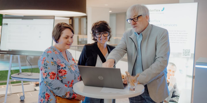 Interflex employees demonstrate the latest Interflex software to event visitors on a laptop.