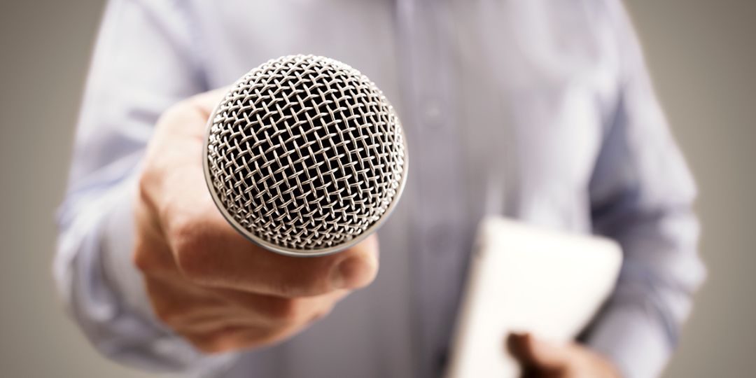 Man houdt microfoon in zijn hand