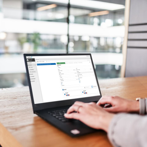 Person am Laptop mit Interflex Besuchermanagement-Software auf dem Monitorbildschirm