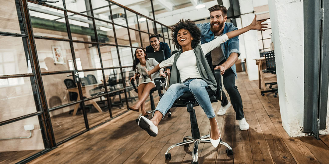 Happy employees laugh together in the office.